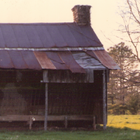 Front view of the log house before it was moved.