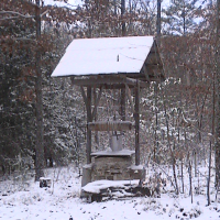 Snow covered well wishing for warmer weather.